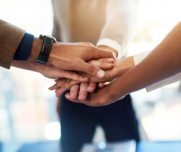 Hands joined by a collaborative industrial team